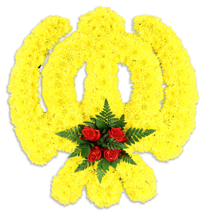 This meticulously constructed Khanda tribute presents the Sikh emblem in a palette of sunlit yellow and deep, dignified red. Thousands of small yellow chrysanthemum heads are arranged with exacting care to outline the circular chakkar, the straight-edged central khanda and the twin kirpans that cross beneath it; the repetition of tiny petals gives the whole piece a plush, tactile surface and a softly rounded relief against the stark white background. Anchoring the composition at its centre, five rich red roses are grouped tightly and cushioned by sprays of dark green fern, their glossy fronds creating a natural frame that heightens the roses' intensity. A delicate, cool shadow beneath the piece reveals it as a standalone floral assembly-sized and shaped to be a focal point during a memorial, a religious observance, or a community commemoration. The sensory impression is gentle: the clean, honeyed note of chrysanthemums mingles with the classic rose sweetness and a faint leafy green aroma from the ferns. From a local perspective-whether placed for a service near Chigwell High Road, at a nearby gurdwara, or as a dignified tribute delivered to a family home-the colours and craftsmanship communicate both respect and hope. The arrangement is designed to be seen up close or from a short distance, its symbolic form readable, its textures inviting a moment of quiet reflection from those who gather.